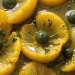 Close-up of yellow poppy recipe showing glistening olive oil and lemon zest.